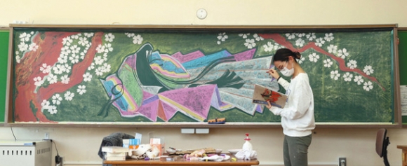 黒板に桜と小野小町の絵を描く山下さん＝名古屋市中区の大須小で