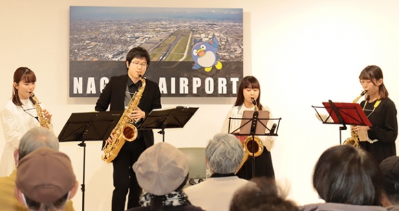 到着ロビーにサックスの音色を響かせる学生たち＝県営名古屋空港で