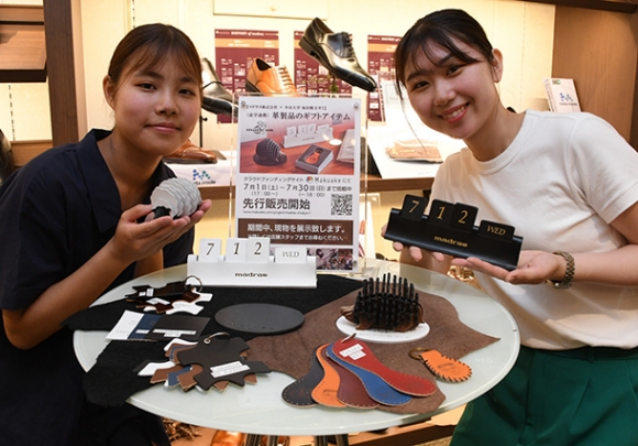 靴製品を作る過程で余る革を活用したグッズを提案した中京大の日比さん（左）と小池さん＝栄のマドラス栄地下店で