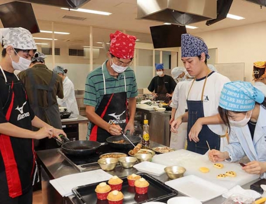 手際良く調理を進める学生＝いずれも春日井市松本町の中部大で