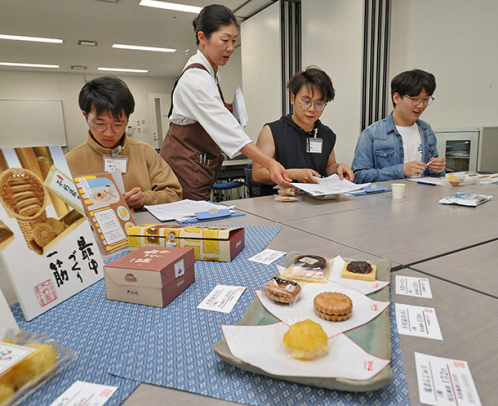 和菓子を試食するアジア地域からの留学生＝名古屋市中村区の愛知大名古屋キャンパスで