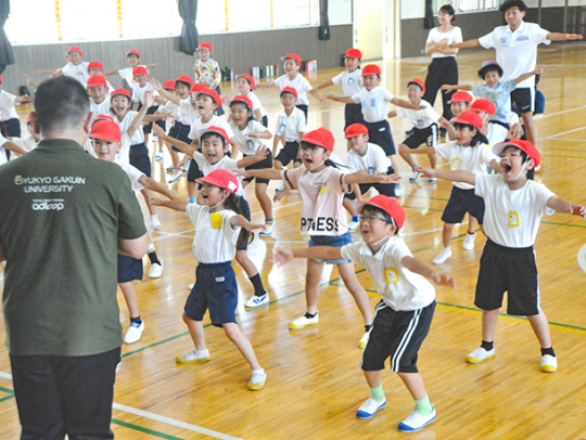 学生たちと一緒に運動遊びをする子どもたち＝中津川市西小で
