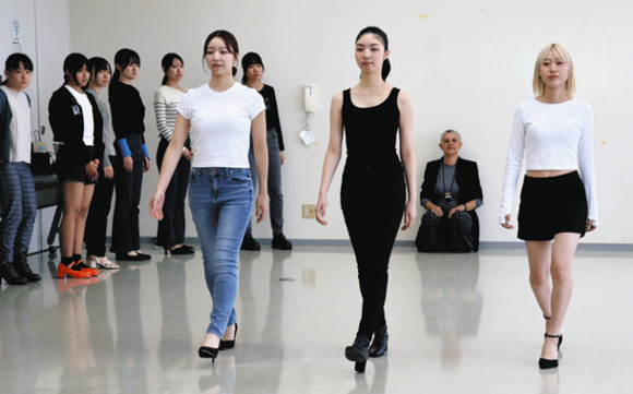 講師(後方)が見守る中、モデルの梨杏さん(手前右から2人目)を手本に歩き方を学ぶ参加者=蒲郡市の蒲郡商工会議所で