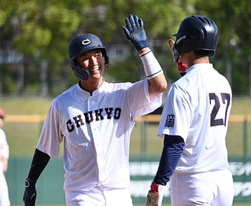 名城大-中京大 タイブレークの10回に勝ち越しの3ランを放ち、仲間とハイタッチする中京大の狩俣(左)=パロマ瑞穂球場で(石曽根和花撮影)