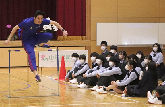 生徒らの前でハードルを越えていく安部さん＝伊勢市河崎の英心高で