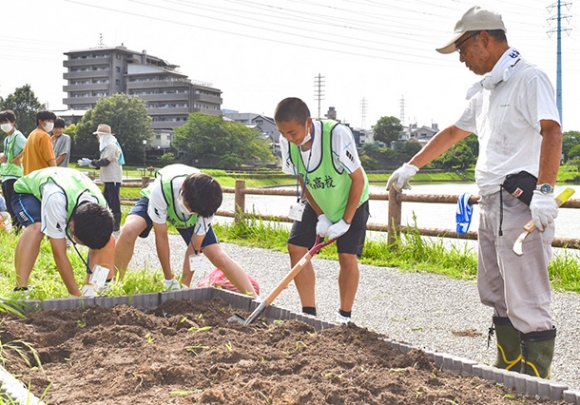  地域の人たちと一緒に花壇を整備する生徒たち＝豊明市新栄町の大蔵池公園で