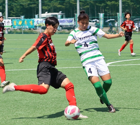 相手と競り合う聖カピタニオ女子の選手（左）＝北海道音更町サッカー場で