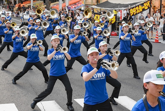 行進しながら息の合った演奏で会場を盛り上げる東邦高と愛知東邦大の混成チーム「ＴＯＨＯ　ＭＡＲＣＨＩＮＧ　ＢＡＮＤ」＝栄の広小路通で