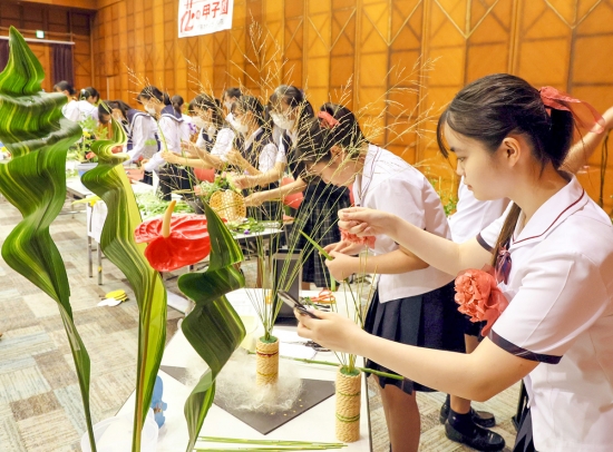 真剣な表情で花を生ける高校生たち＝名古屋・栄の松坂屋名古屋店で