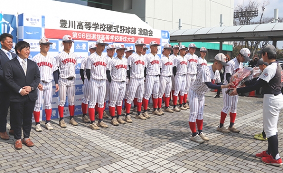 小坂井ボーイズのメンバー（右端）から花束を贈られる豊川高野球部員＝豊川市総合体育館前で