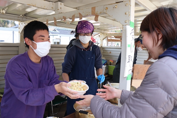 被災者に食事を提供する生徒（左）＝石川県輪島市の三井公民館で