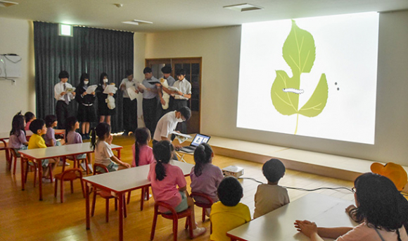 紙芝居を映してカイコの一生を伝える生徒たち＝豊明市沓掛町の沓掛けやき保育園で