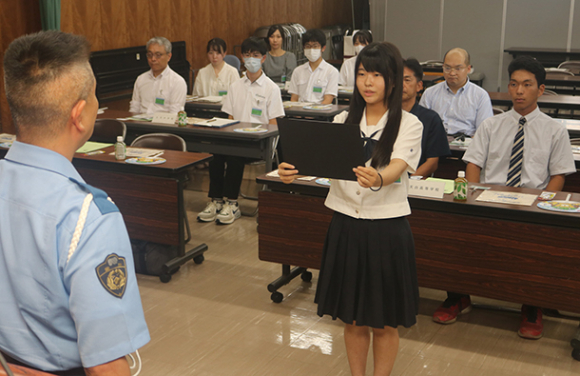 杉原基彦署長（手前左）に向けて無事故・無違反の宣言をする女子生徒（同右）＝天白署で