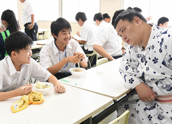 ちゃんこを振る舞って生徒と交流する力士（右）＝岐阜市野一色の岐阜東中高で