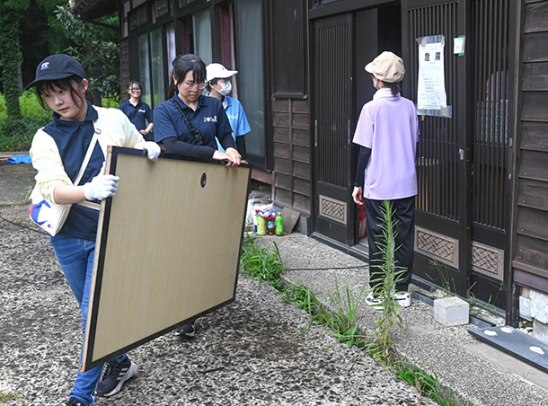 家財道具を運び出す生徒たち＝石川県輪島市町野町で