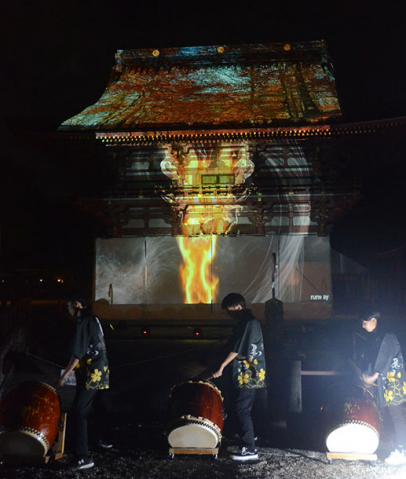 楼門に映し出された映像を前に演奏する生徒ら＝津島市の津島神社で