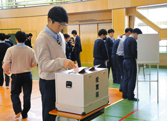 実際の投票箱や記載台を用いて模擬投票する生徒ら＝豊橋市鍵田町の豊橋中央高で