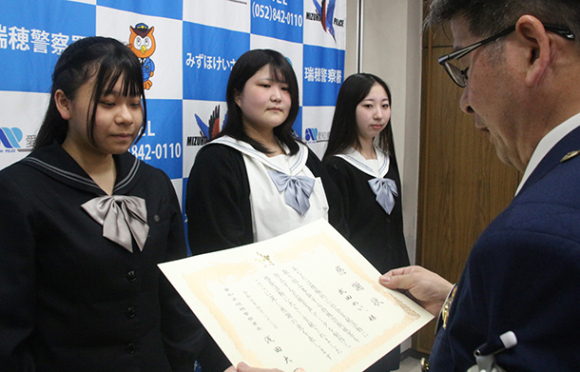 感謝状を受け取る名古屋葵大中学校・高校放送部の武田部長(左)ら=瑞穂署で