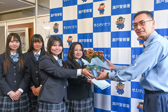 鉢花を井上署長に手渡す生徒たち=瀬戸市原山町の瀬戸署で