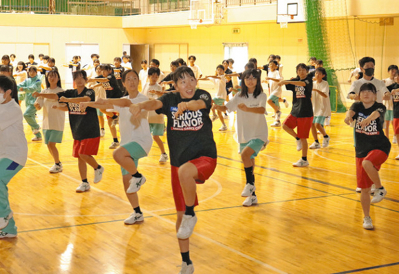 三重高ダンス部の部員と一緒に踊る生徒たち=松阪市中部中で