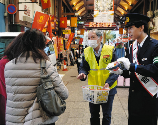 一日警察官を委嘱され交通安全の啓発活動に取り組む生徒（右）＝中区の大須商店街で