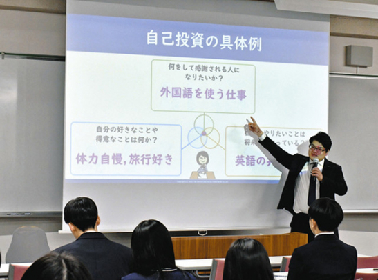 スライドを使いながら投資について説明する長堂さん（奥）＝多治見市明和町の多治見西高で