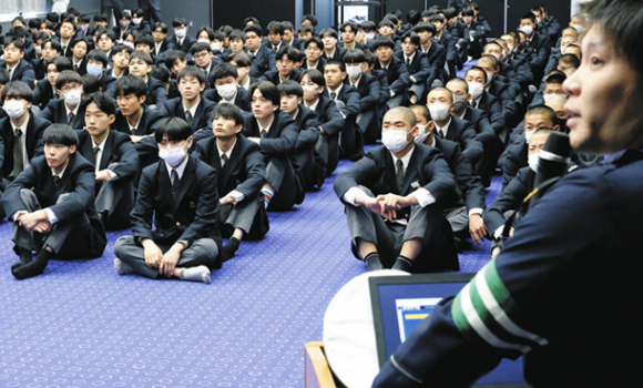 中署員（手前）から自転車に乗る際の交通ルールを学ぶ生徒たち＝中区伊勢山１の名古屋たちばな高校で