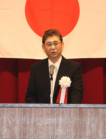 入学式で抱負を述べる新理事長の金子氏＝鈴鹿市庄野町の鈴鹿高で