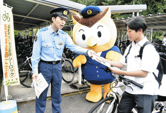 ツーロックの徹底を呼びかける署員（左）とコノハけいぶ（中）＝日進市三本木町の中部大第一高で