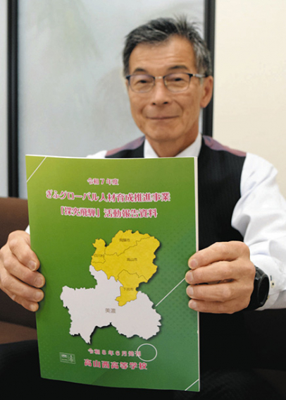 「探究飛騨」の成果をまとめた冊子を紹介する小林理事長＝中日新聞高山支局で
