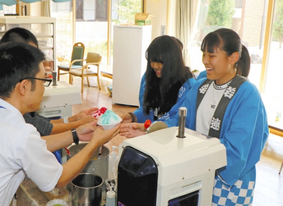 夏祭りの運営を手伝う高校生たち(右側)=名古屋市守山区で