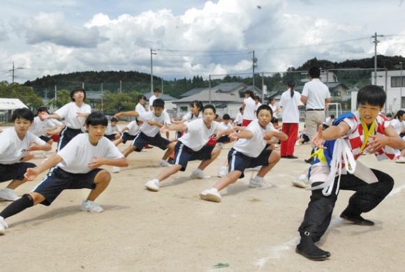 中京院中京高の生徒(右)から踊りの基本動作を学ぶ恵那東中2年生ら=恵那市の同中で
