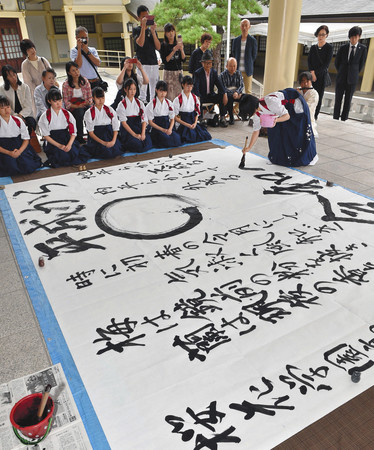 平和を祈り、揮毫する桜花学園高書道部の生徒たち＝中区の県護国神社で