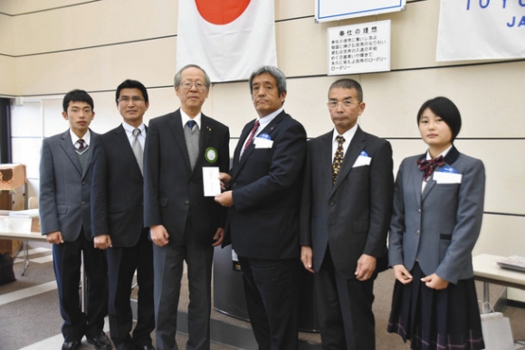 豊川高駅伝部に激励金を贈る豊川RCの川合会長(左から3人目)=豊川市の豊川商工会議所で