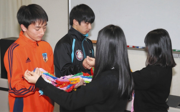 全校生徒でつくった千羽鶴を受け取る選手代表(左)=瑞浪市土岐町の中京院中京高で