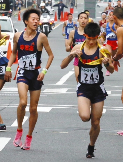 中京院中京の２区・安藤選手（右）にたすきを渡す１区・中洞選手（左）＝京都市内で
