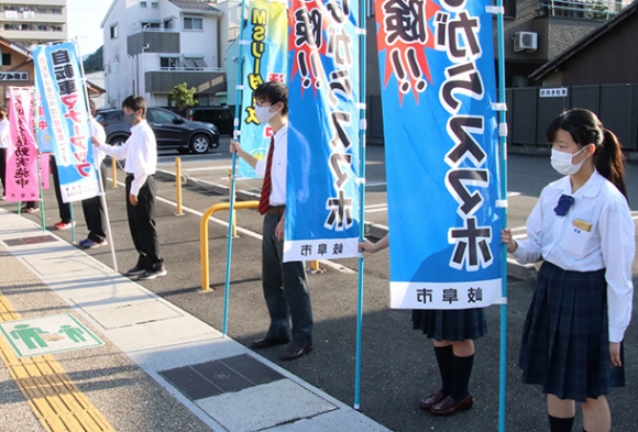 のぼり旗を持って交通安全を呼び掛けるＭＳリーダーズの高校生＝岐阜市梶川町で