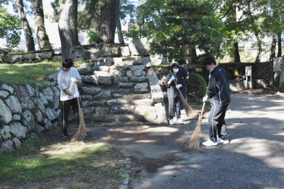 公園内の枯れ葉を集める生徒たち＝津市丸之内のお城公園で