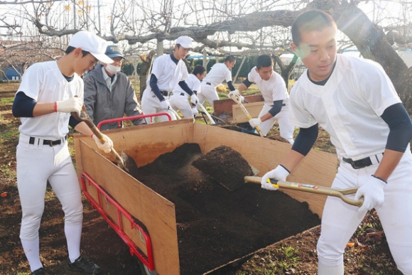 堆肥をまく作業をボランティアで手伝う部員たち＝美濃加茂市の山鈴農園で