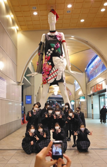 ナナちゃんと記念写真を撮る愛知啓成高の生徒たち＝名古屋・名駅で