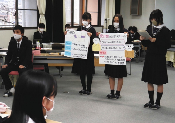 主張をまとめた紙を掲げて主張を述べる弁護人役の生徒たち=多治見市の多治見西高で