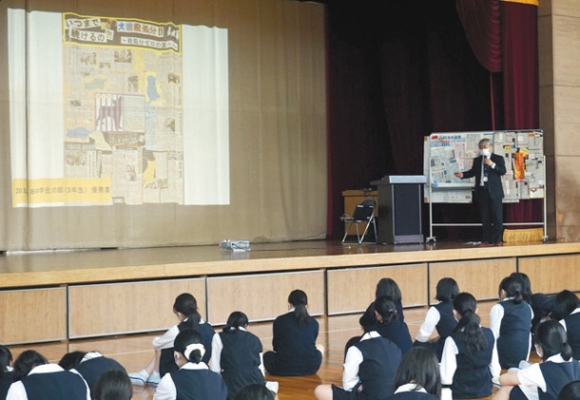 新聞切り抜き作品の作り方を生徒たちに伝える二宮さん（右端）＝昭和区の南山高女子部で