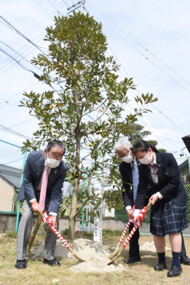 植樹する女子生徒（右）と稲沢ＲＣ会員＝稲沢市の愛知啓成高で