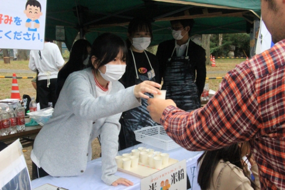 津まつりの会場で炭酸飲料の試作品を配る生徒たち＝津市大門で