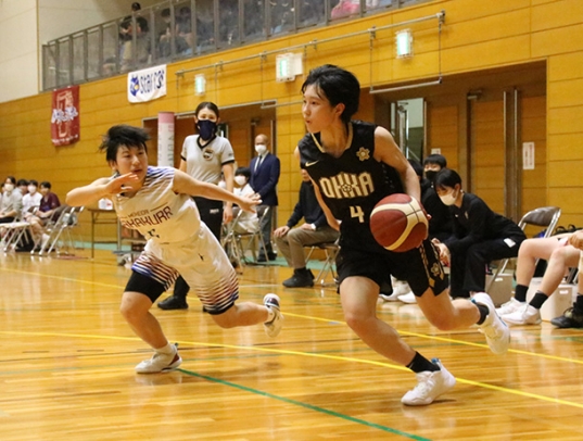 ドリブルで相手選手を抜き去る桜花学園の横山主将（右）＝名古屋市北スポーツセンターで