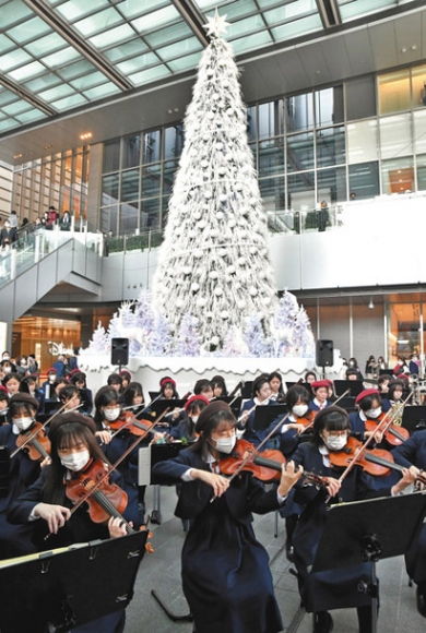 クリスマスツリーの前で演奏する生徒たち＝ＪＲ名古屋駅前で