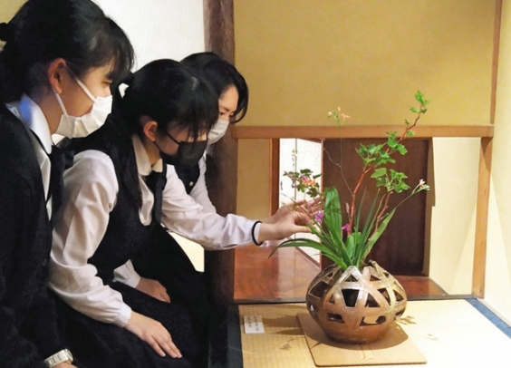 展示された花器に花を生ける椙山女学園高華道部の生徒たち＝千種区堀割町１の為三郎記念館で