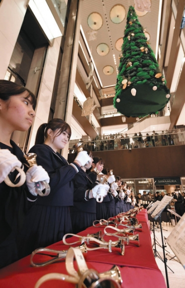 クリスマスにハンドベルの音色を響かせる金城学院高の生徒ら＝名古屋・名駅のミッドランドスクエアで
