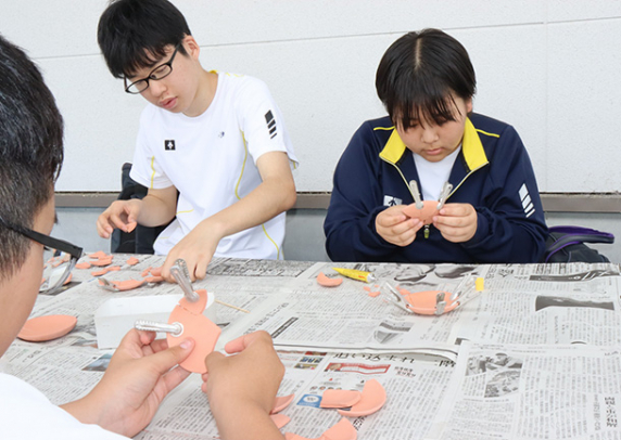 土器の復元作業を体験する生徒たち＝明和町斎宮で
