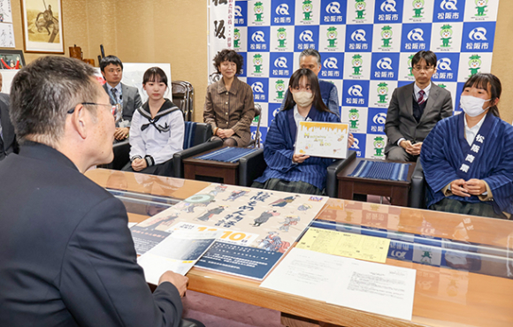 竹上市長（左）に「松阪もめん物語」の企画を紹介する生徒ら＝松阪市役所で